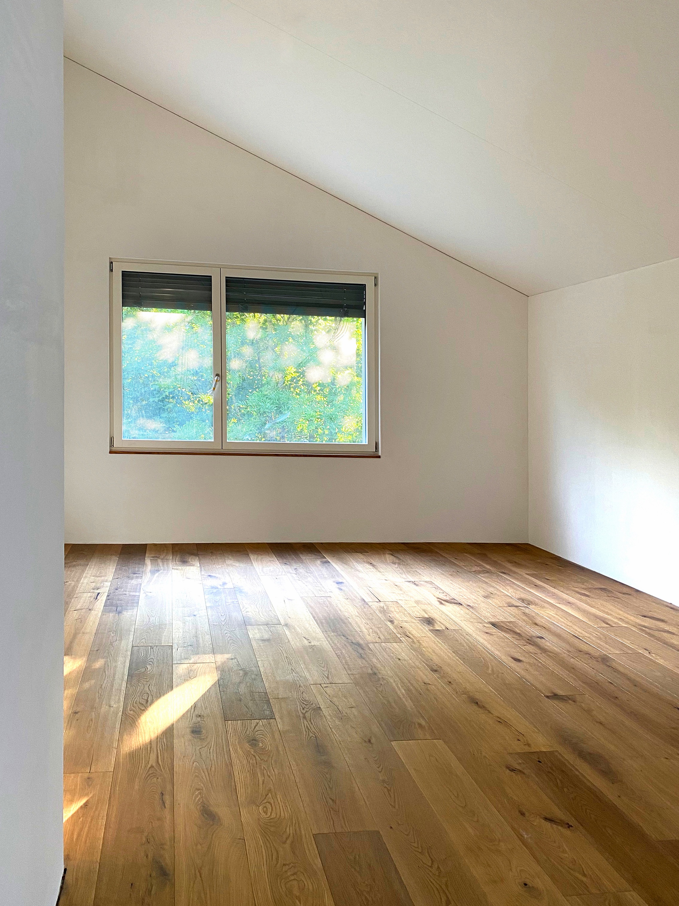 Innenraum mit Holzboden und Dachschräge